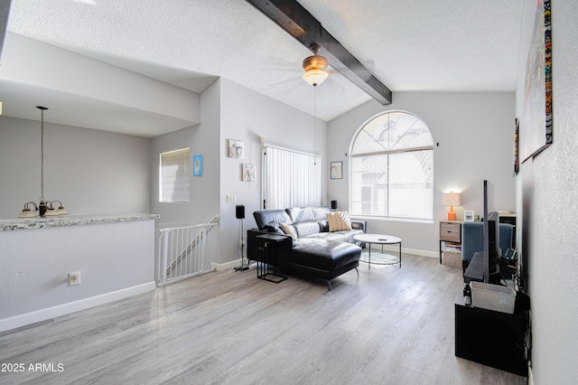 living room featuring wood-type flooring, lofted ceiling with beams, and a textured ceiling