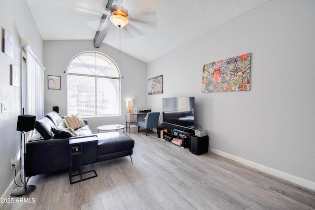 living room with ceiling fan, hardwood / wood-style flooring, lofted ceiling with beams, and a textured ceiling