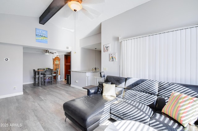 living room featuring ceiling fan, beam ceiling, high vaulted ceiling, and light hardwood / wood-style flooring