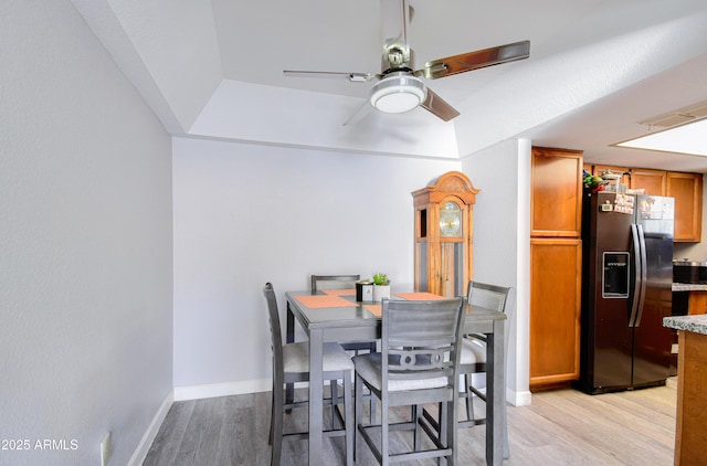 dining space with ceiling fan and light wood-type flooring