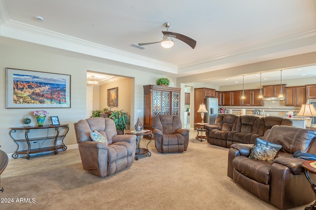 living room with light hardwood / wood-style flooring, ceiling fan, and ornamental molding