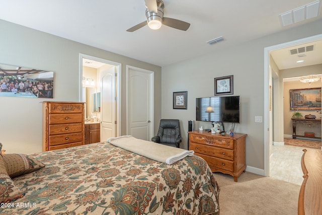 carpeted bedroom with ensuite bath and ceiling fan