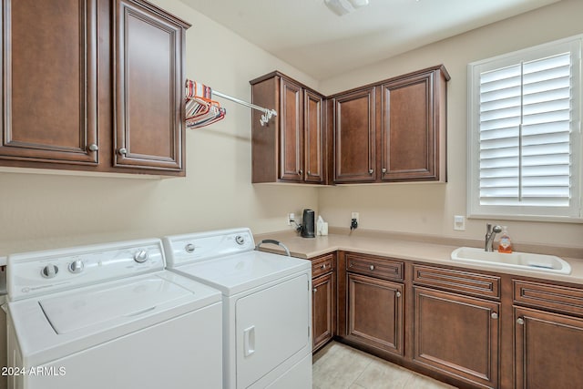 washroom featuring washer and dryer, sink, light tile patterned floors, and cabinets