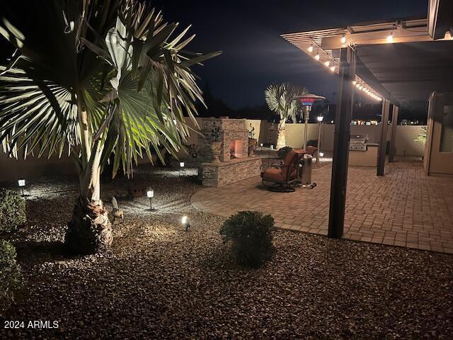 yard at night featuring a patio area and exterior kitchen