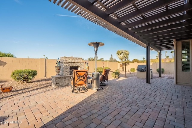 view of patio / terrace with area for grilling and an outdoor stone fireplace