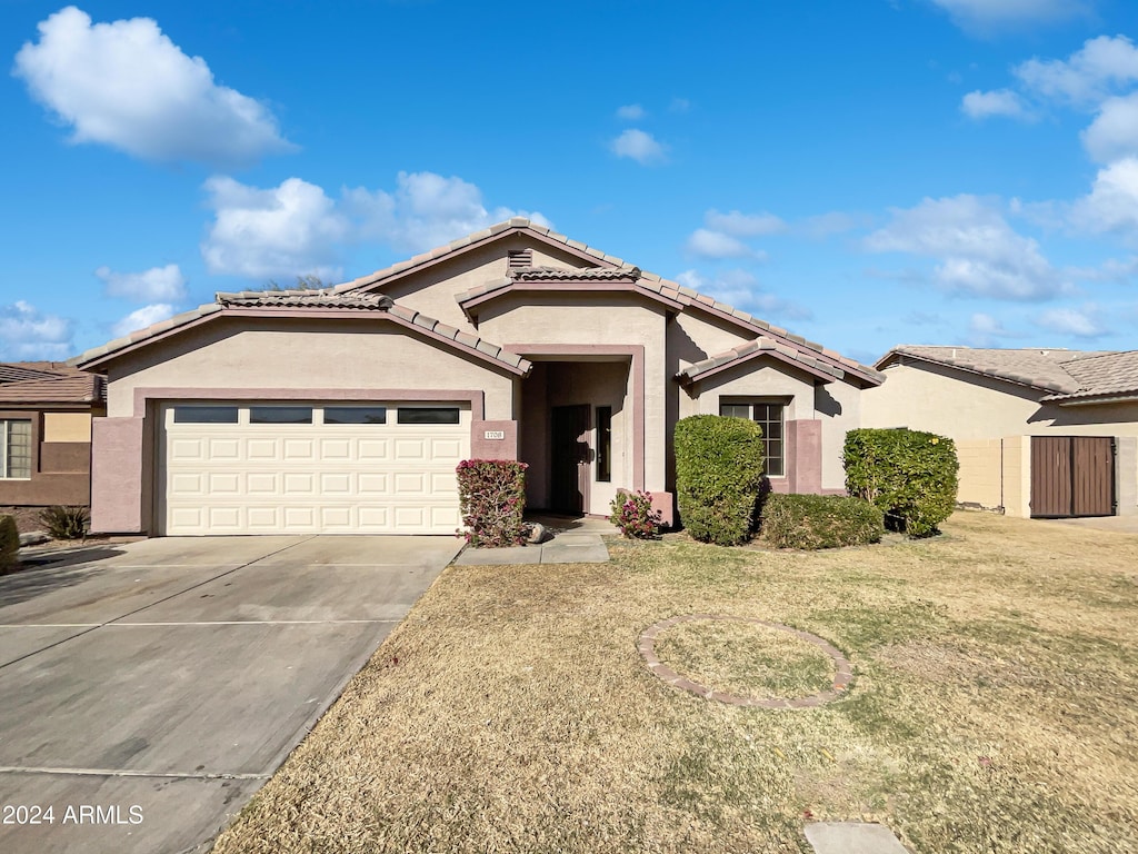 view of front of home with a front yard and a garage