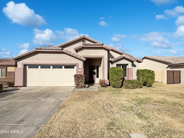 view of front of home with a front yard and a garage