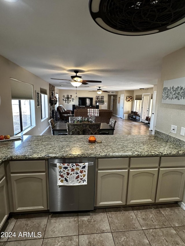 kitchen with kitchen peninsula, light stone counters, ceiling fan, dishwasher, and light tile patterned flooring