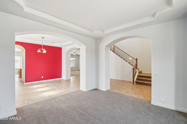 5557 W Mine Trl, Phoenix, AZ 85083 - unfurnished room with a tray ceiling, arched walkways, carpet floors, and stairway