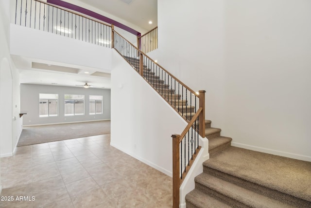 5557 W Mine Trl, Phoenix, AZ 85083 - staircase featuring carpet flooring, baseboards, ceiling fan, a towering ceiling, and tile patterned floors