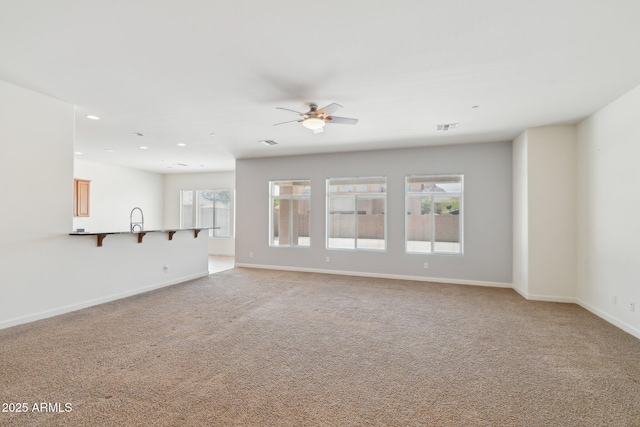 5557 W Mine Trl, Phoenix, AZ 85083 - unfurnished living room featuring light colored carpet, baseboards, ceiling fan, recessed lighting, and a sink