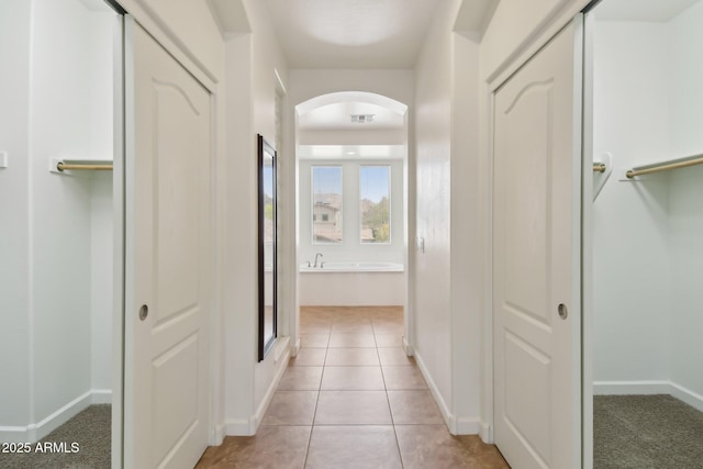 5557 W Mine Trl, Phoenix, AZ 85083 - corridor with arched walkways, baseboards, and light tile patterned floors