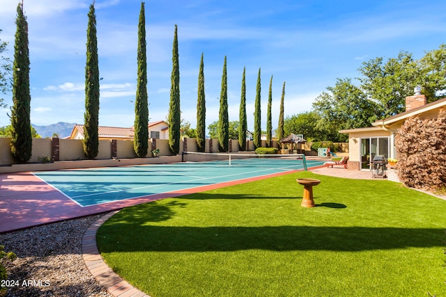 exterior space with a lawn and tennis court