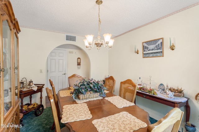 carpeted dining area featuring a chandelier, a textured ceiling, and ornamental molding