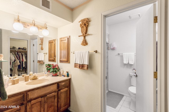 bathroom with tile patterned flooring, vanity, toilet, and a textured ceiling