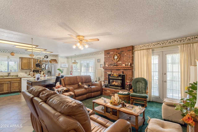 living room with a fireplace, french doors, a textured ceiling, and ceiling fan