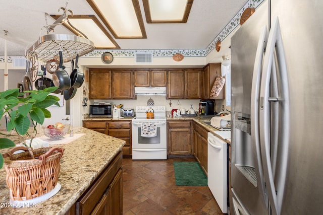 kitchen with light stone counters and appliances with stainless steel finishes