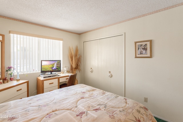 bedroom featuring crown molding, a closet, and a textured ceiling