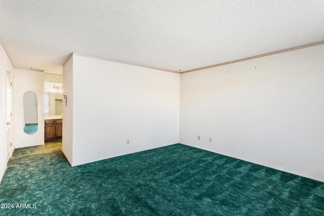 carpeted empty room featuring a textured ceiling and ornamental molding