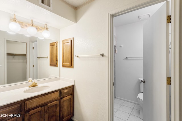 bathroom with tile patterned flooring, vanity, a textured ceiling, and toilet