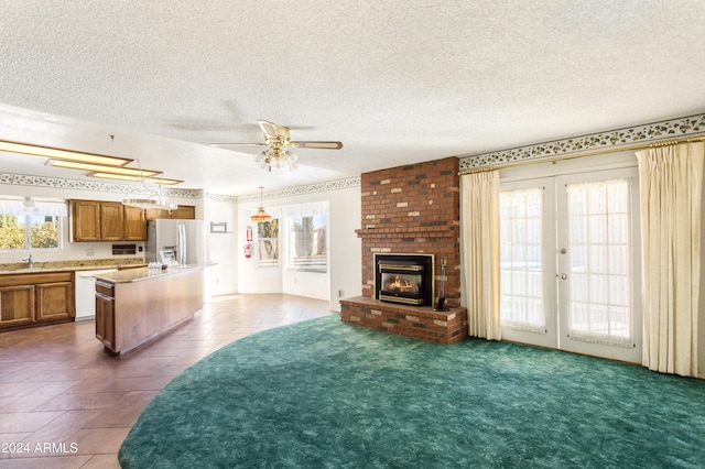 living room with french doors, dark carpet, and a healthy amount of sunlight