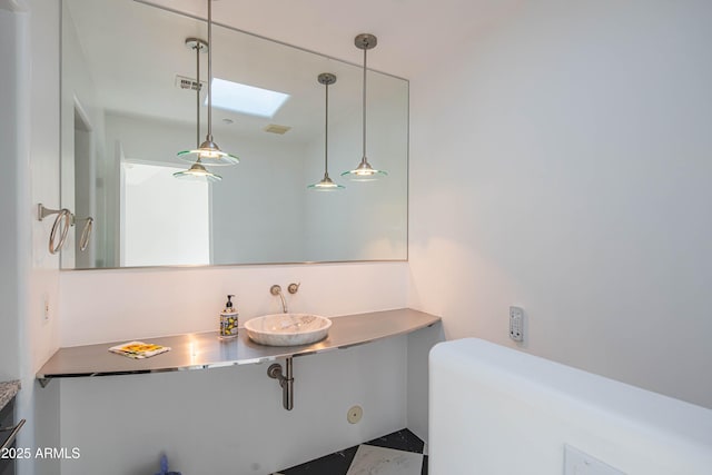 bathroom featuring sink and a skylight