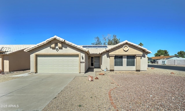 single story home with a tile roof, an attached garage, driveway, solar panels, and stucco siding