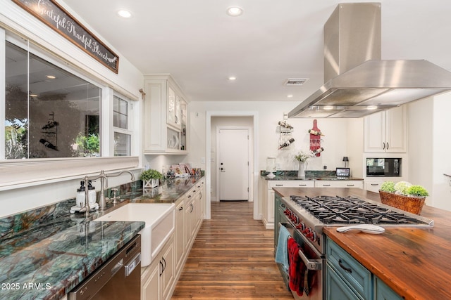 kitchen with dark wood-style flooring, high end stainless steel range oven, dishwasher, island range hood, and butcher block counters