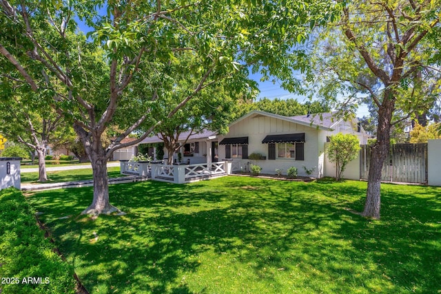view of front of house with a front yard and fence