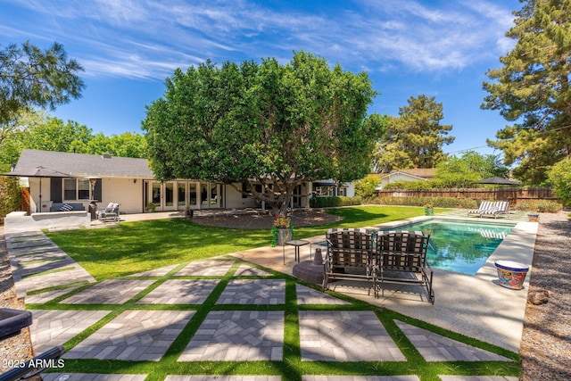 view of swimming pool with fence, a patio area, and a yard