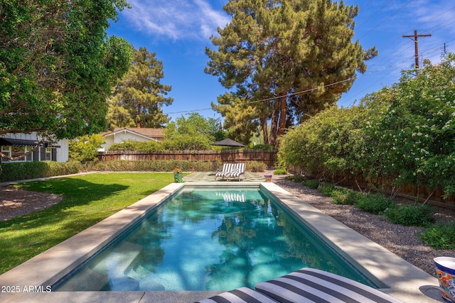 view of swimming pool with a lawn, a fenced in pool, and a fenced backyard