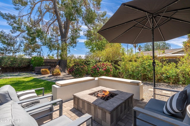 view of patio / terrace with an outdoor living space with a fire pit and a fenced backyard
