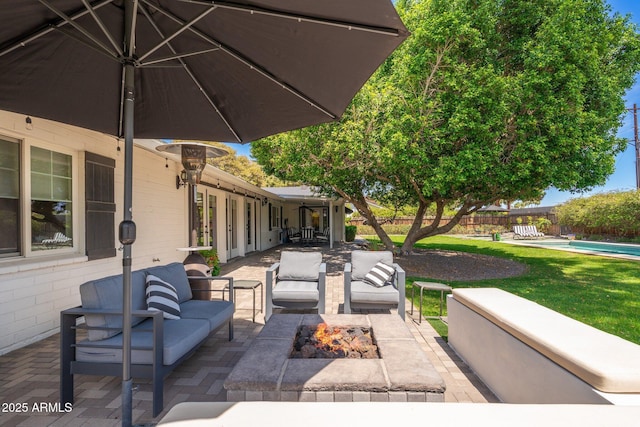 view of patio featuring fence, an outdoor living space with a fire pit, and an outdoor pool