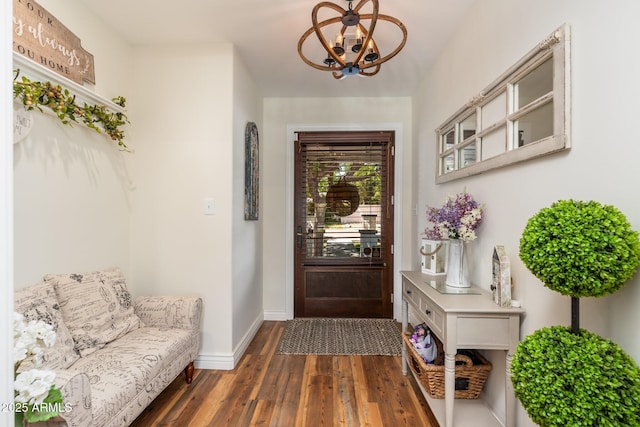 interior space featuring dark wood-style floors, baseboards, and a chandelier