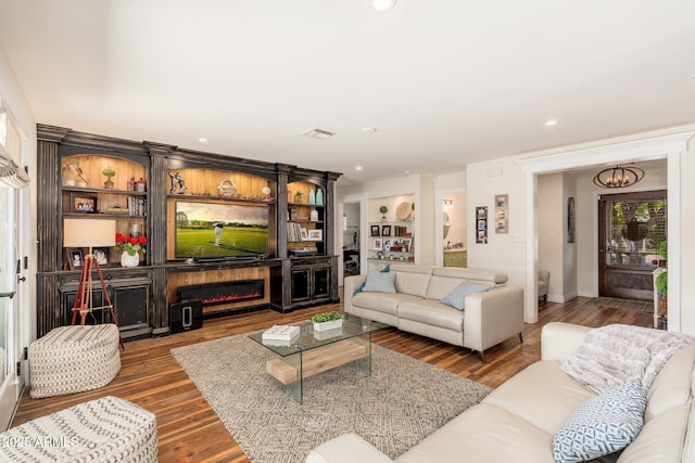 living room with an inviting chandelier, wood finished floors, recessed lighting, and baseboards