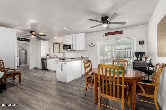 dining space with sink, dark wood-type flooring, ceiling fan, electric water heater, and a textured ceiling