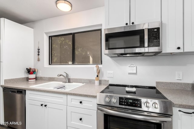 kitchen featuring stainless steel appliances, sink, and white cabinets