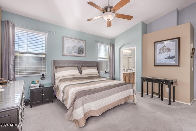 carpeted bedroom with vaulted ceiling, ceiling fan, and ensuite bathroom