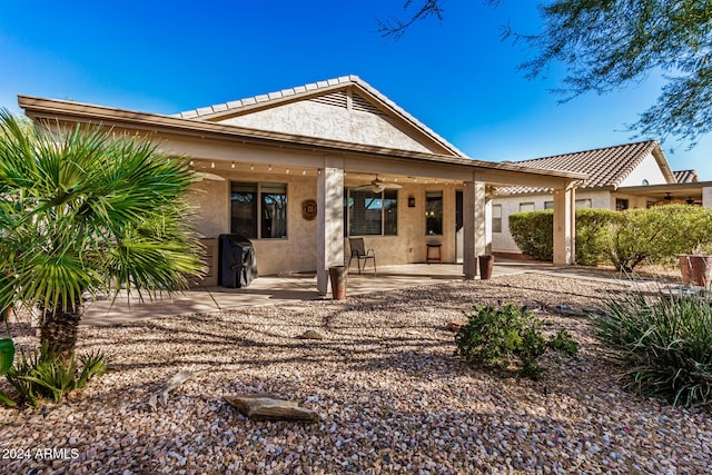 rear view of house featuring ceiling fan and a patio area