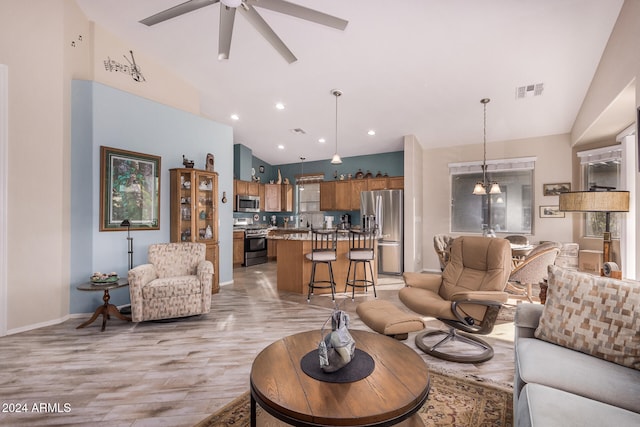 living room featuring high vaulted ceiling, light wood-type flooring, sink, and ceiling fan with notable chandelier