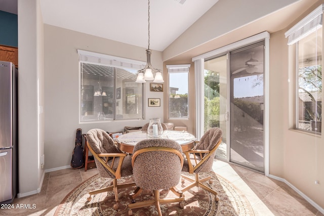 dining room with light tile patterned flooring, an inviting chandelier, and vaulted ceiling