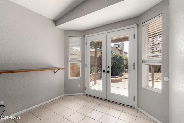 entryway with french doors, a textured wall, baseboards, and light tile patterned floors