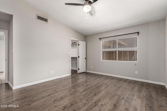 unfurnished room with baseboards, visible vents, a ceiling fan, lofted ceiling, and dark wood-style flooring