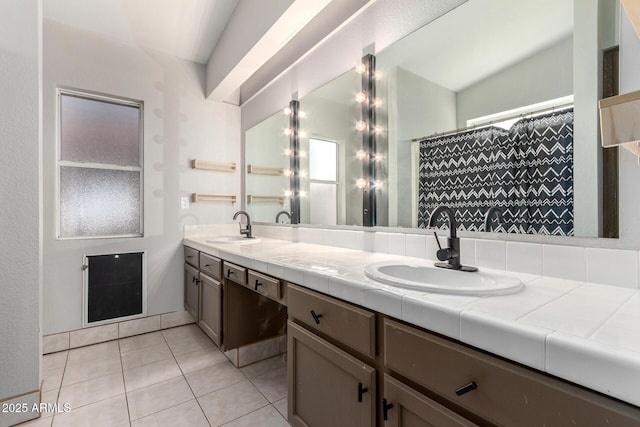 bathroom with double vanity, a sink, and tile patterned floors