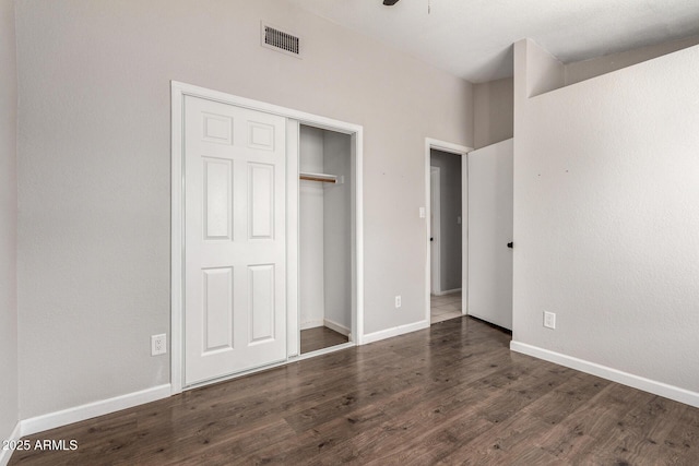 unfurnished bedroom featuring a closet, visible vents, baseboards, and wood finished floors