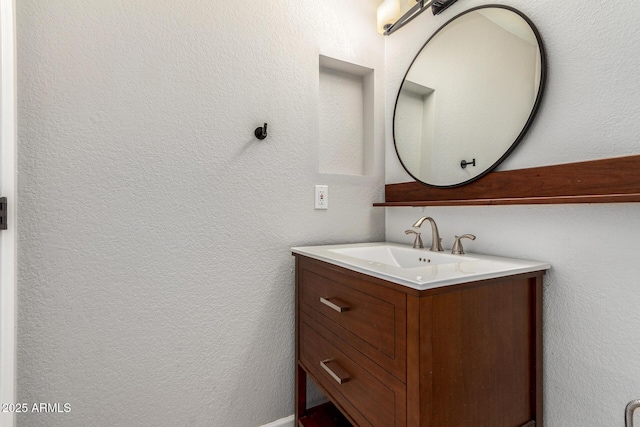 bathroom featuring a textured wall and vanity