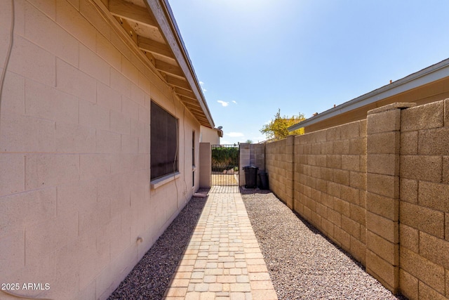 view of side of property featuring fence and a gate