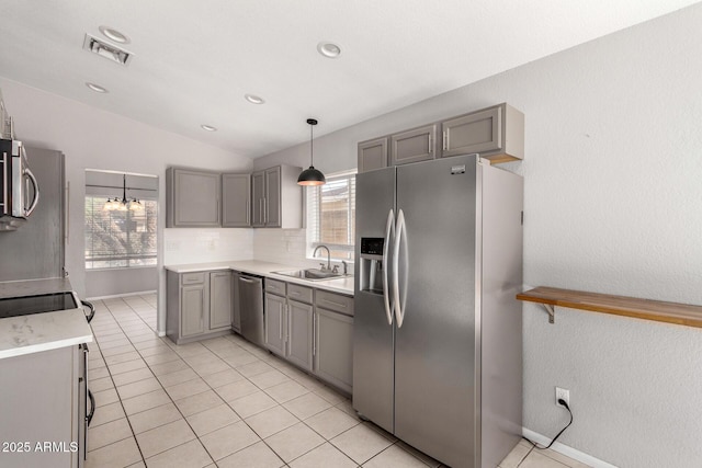 kitchen featuring lofted ceiling, stainless steel appliances, a sink, visible vents, and gray cabinets