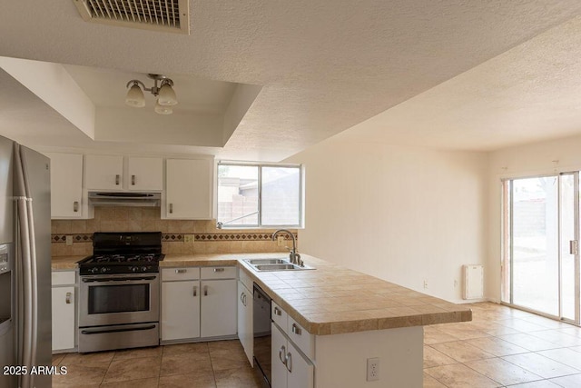 1315 Via Cabrillo, Sierra Vista, AZ 85635 - kitchen featuring appliances with stainless steel finishes, a sink, under cabinet range hood, a peninsula, and light tile patterned floors