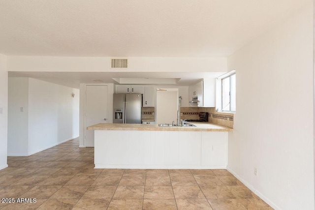 1315 Via Cabrillo, Sierra Vista, AZ 85635 - kitchen with stainless steel fridge, a peninsula, light countertops, stove, and white cabinetry